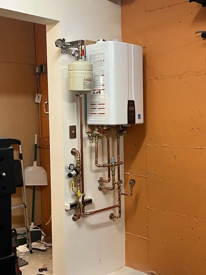 Plumbing technician inspecting water heater connections in Plymouth
